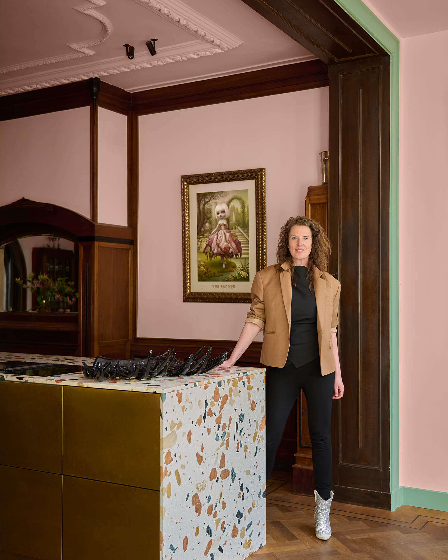 Jessica Kersten, founder of Living With Daydreams, in her pink kitchen with a terrazzo island