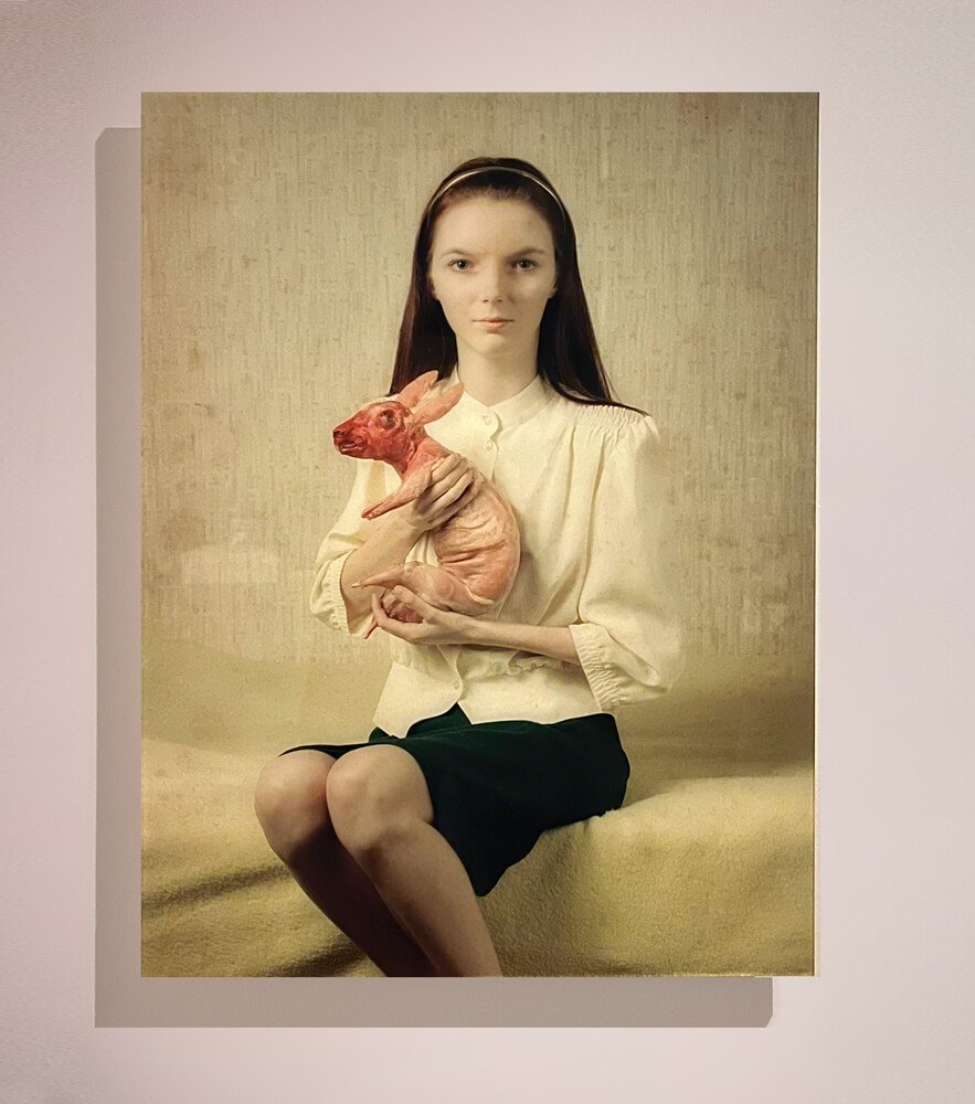 Photography print by Koen Hauser: young woman in a white blouse holding a pink animal figure