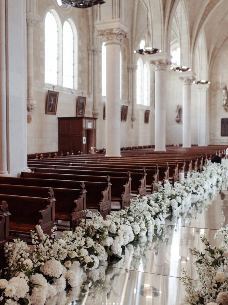 Church aisle lined with white flowers