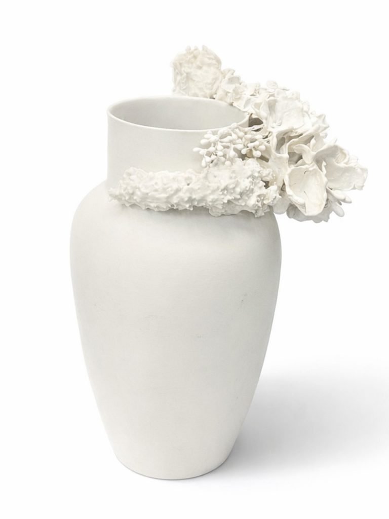 White porcelain vase with sculpted flowers along the rim